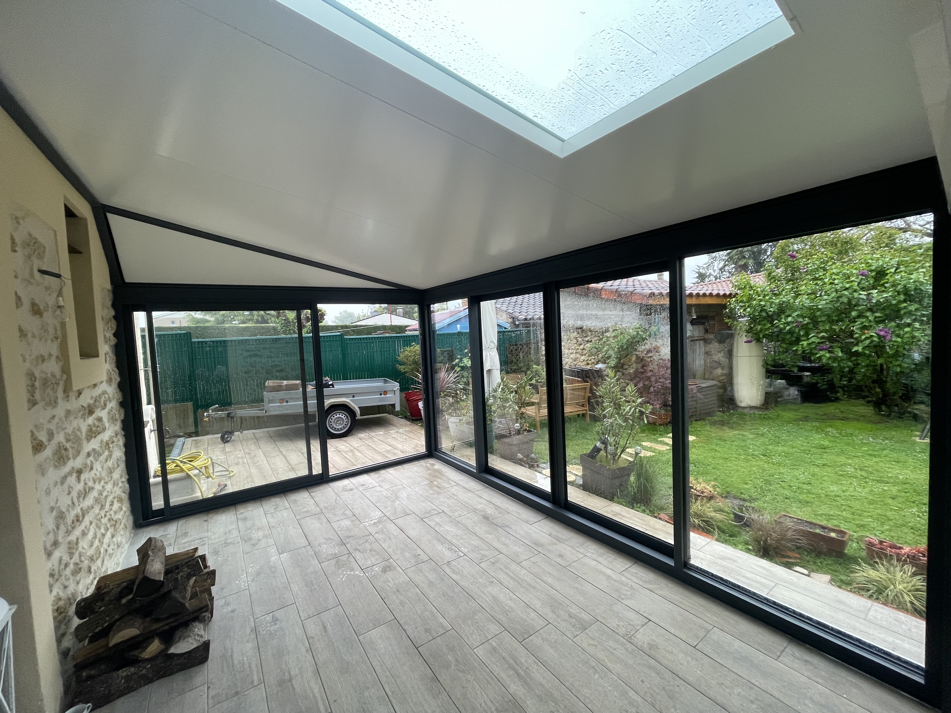 Intérieur véranda aluminium avec vue jardin